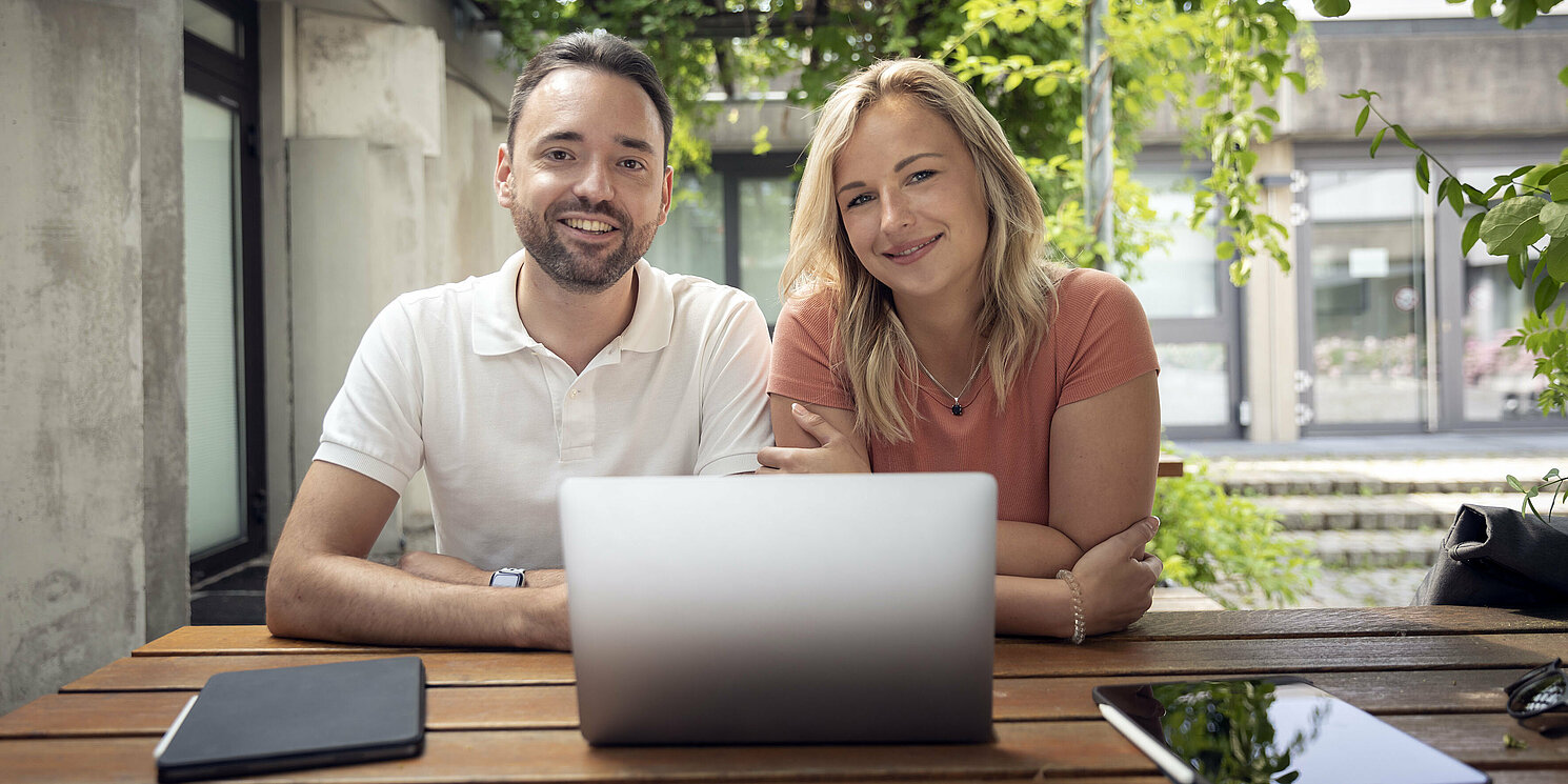 Die Studierenden haben die OTH Regensburg im CHE-Ranking 2026 hervorragend bewertet. Foto: OTH Regensburg/Florian Hammerich Ein Mann und eine Frau sitzen in einem Innenhof vor einem Laptop
