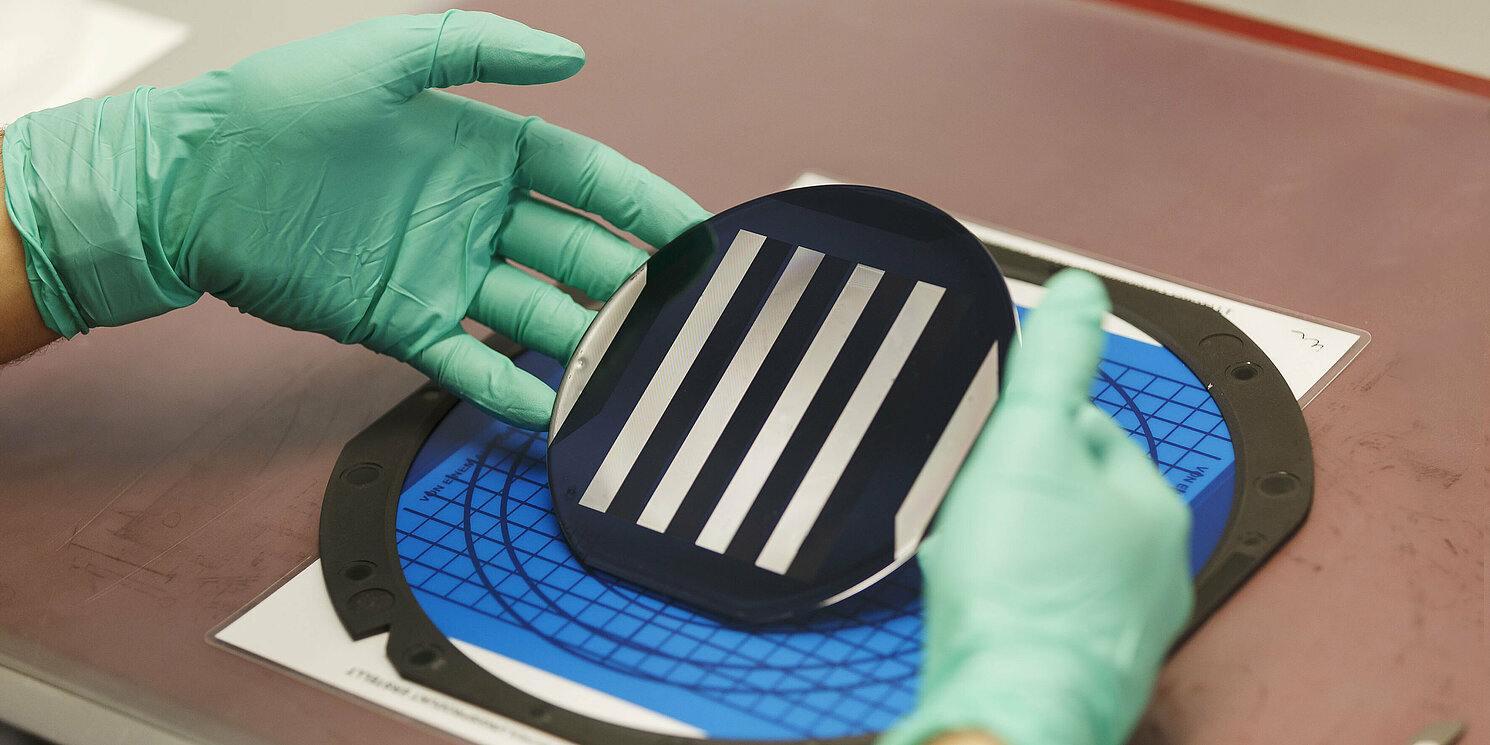 Zwei Hände legen eine Platine auf